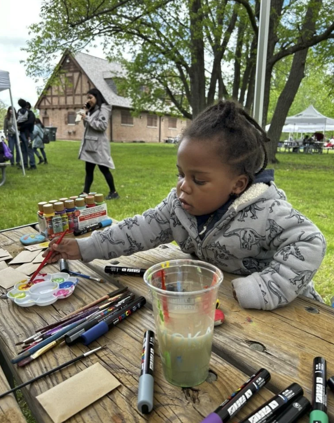 A child painting a bright rock for pollinators