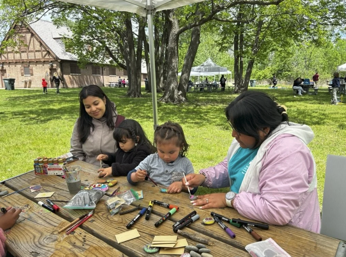Families painting rocks together at the Phoenix Farms table
