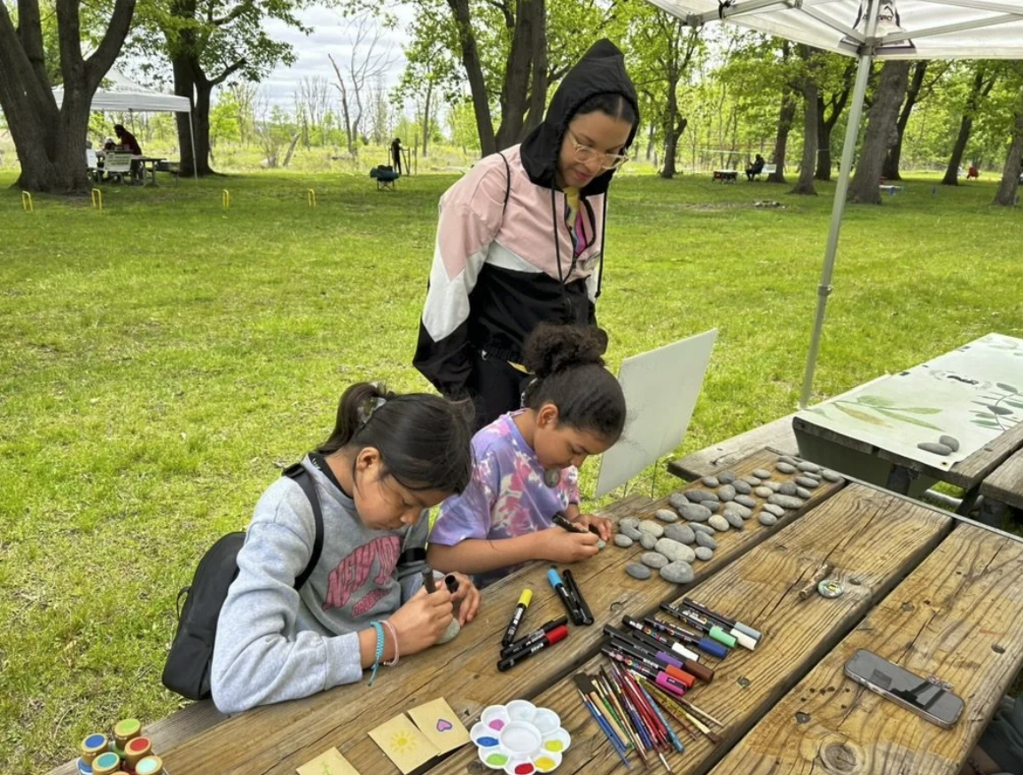 Rock painting supplies and participants at Eggers Grove